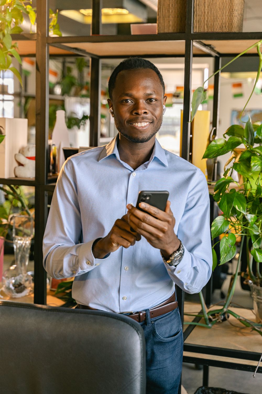 Homem sorrindo enquanto usa o celular